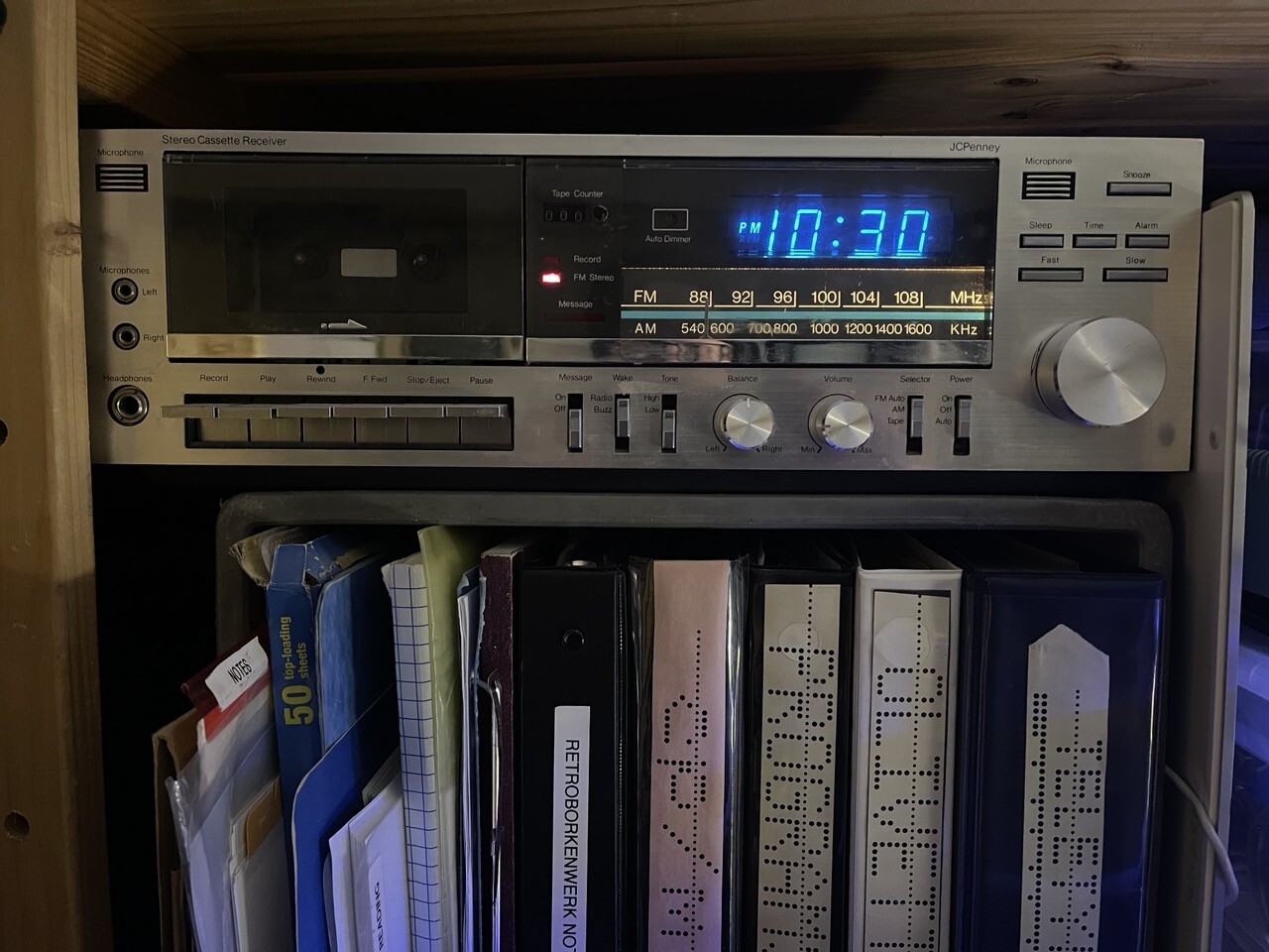 A 1980s console clock radio with cassette player and VFD display. 