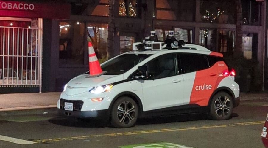 photograph of a cone placed on top of a self-driving car posted by @SafeStreetRebel@sfba.social